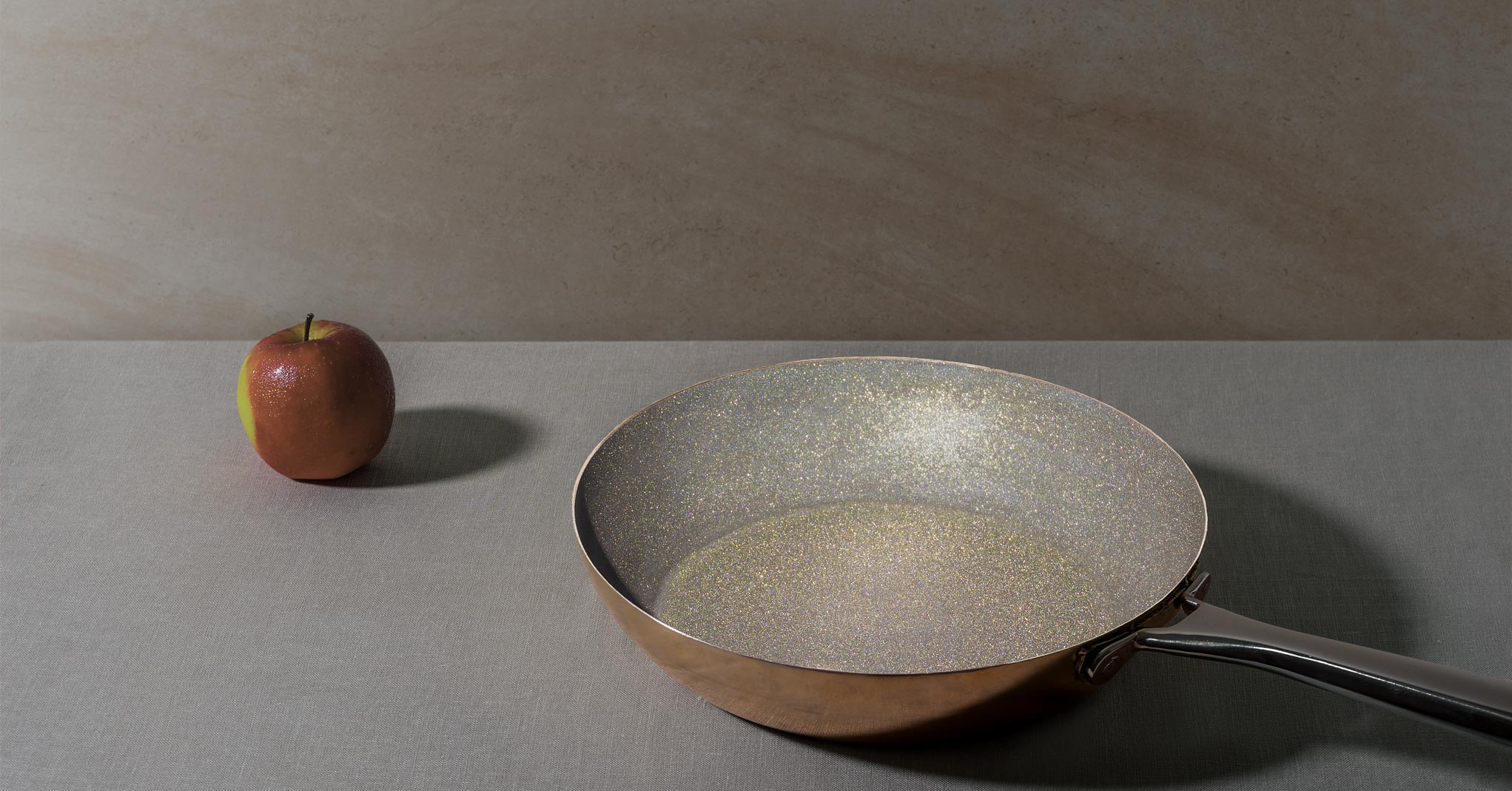 diamond frying pan sparkling interior with apple on table