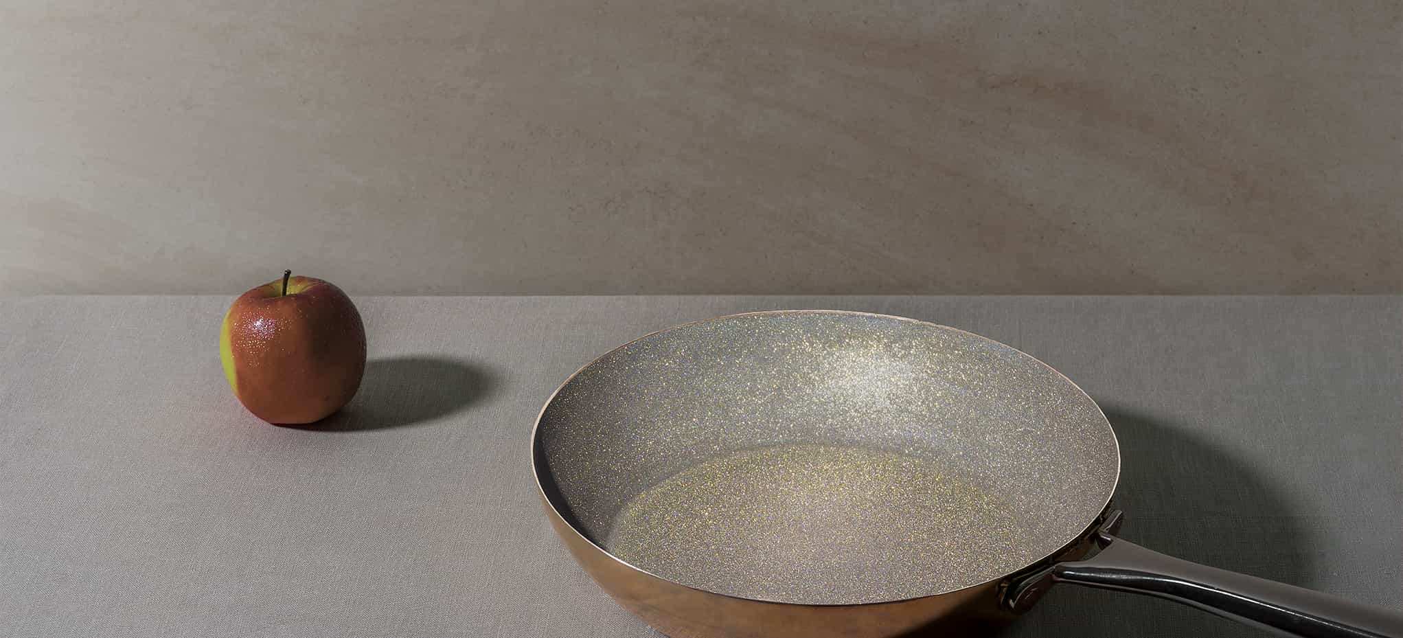 diamond frying pan sparkling interior with apple on table